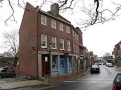 Photo of a three story brick building and a street.